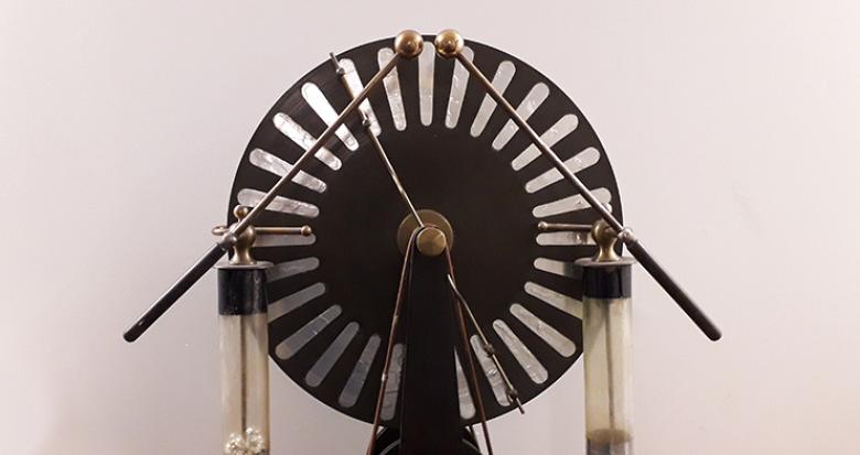 Machine de Wimshurst. Début XXe siècle. Fer, ébonite, étain, laiton, verre, socle en acajou. Dimensions : L 52 cm ; P 27 cm ; H. 64 cm. Machine de Wimshurst. Début XXe siècle. Fer, ébonite, étain, laiton, verre, socle en acajou. Dimensions : L 52 cm ; P 27 cm ; H. 64 cm.